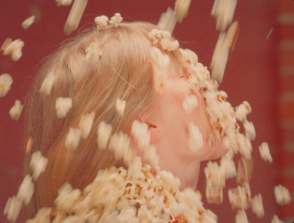 Kuvassa naisen päälle sataa popcornia. Kuvateksti: Yllätysten yritystapahtuma Högforsin ruukissa. Tapahtumatehdas Vakava järjestää!